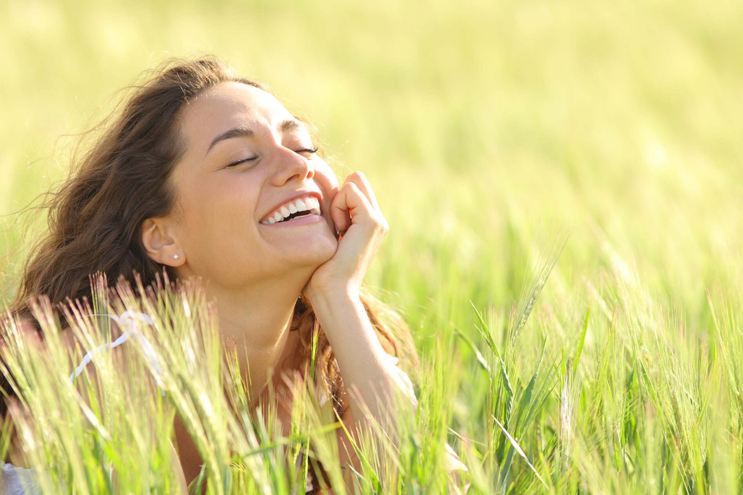 Funny woman enjoying of nature laughing in a field